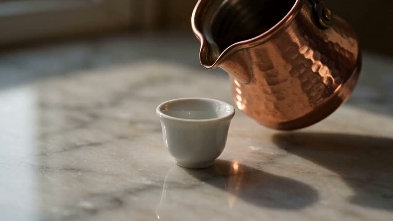 Minyatür dünya: küçücük cezveden fincana dökülen Türk kahvesi, tilt-shift makro çekim. Seedance 2.5 ile üretilen videodan bir kare.